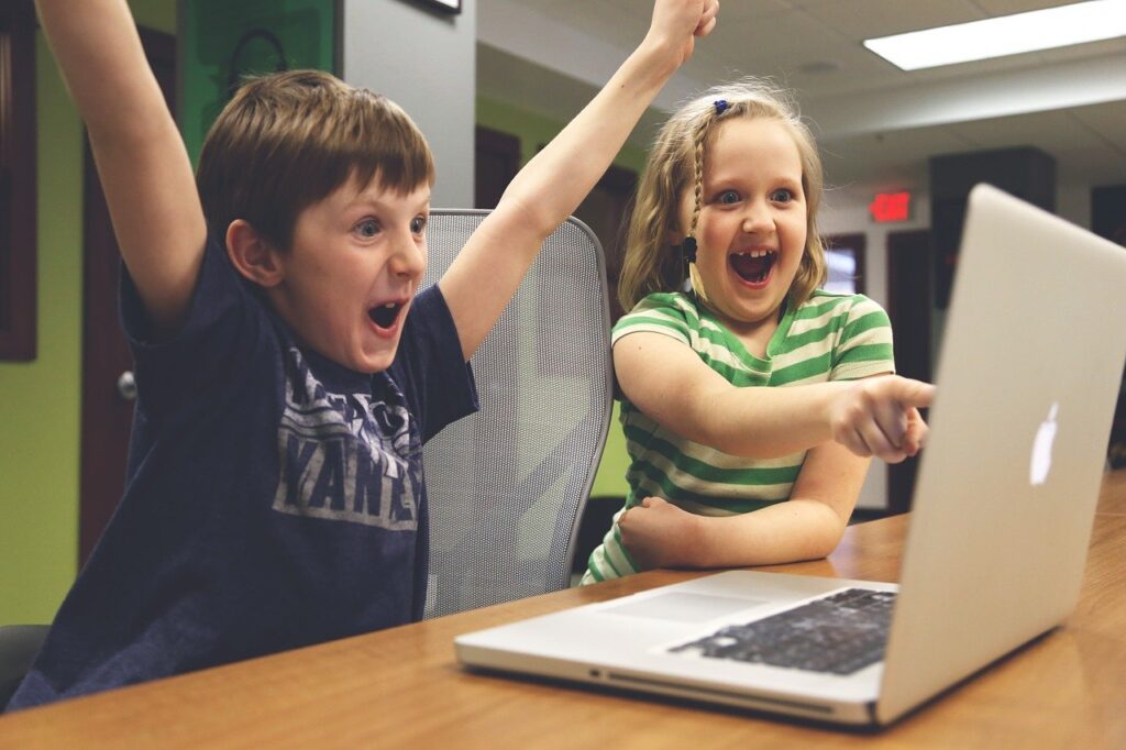 パソコンの前で喜びの表情になる子どもたち