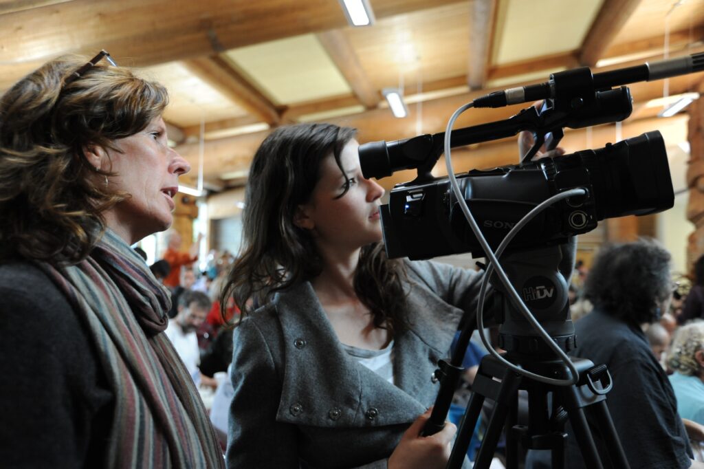 カメラで撮影する報道機関の二人の女性